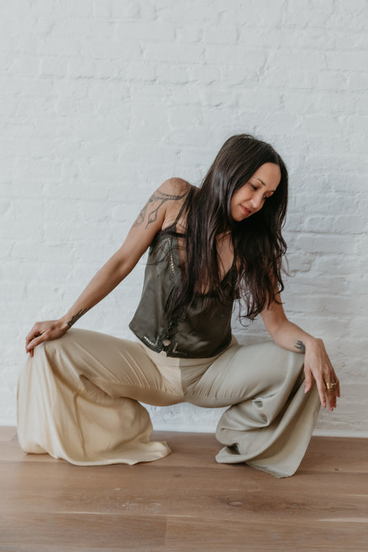 women wearing Elegant wide leg silk pants in soft green and champagne tones