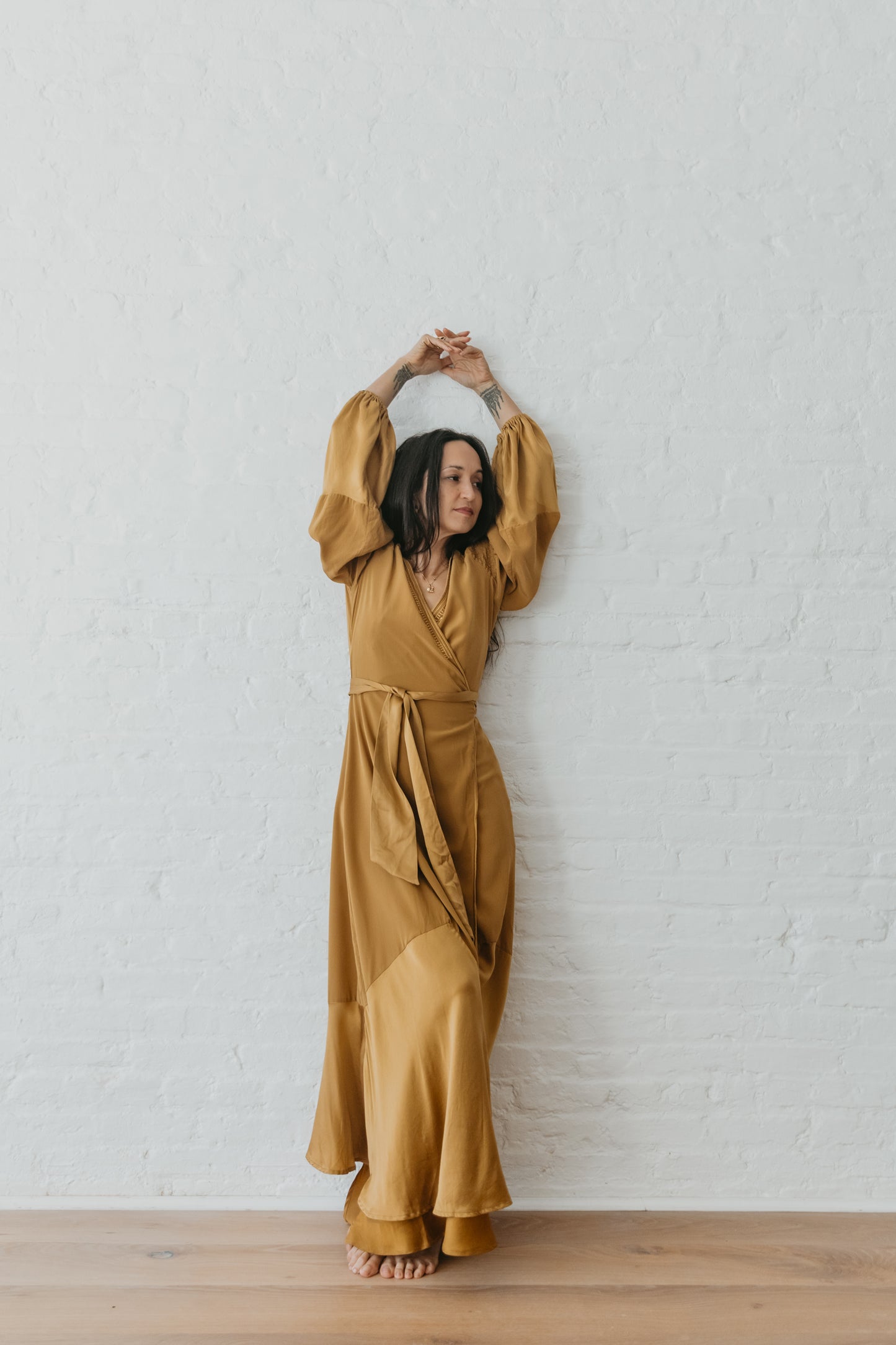 women wearing Goddess inspired silk wrap dress in warm brass tone
