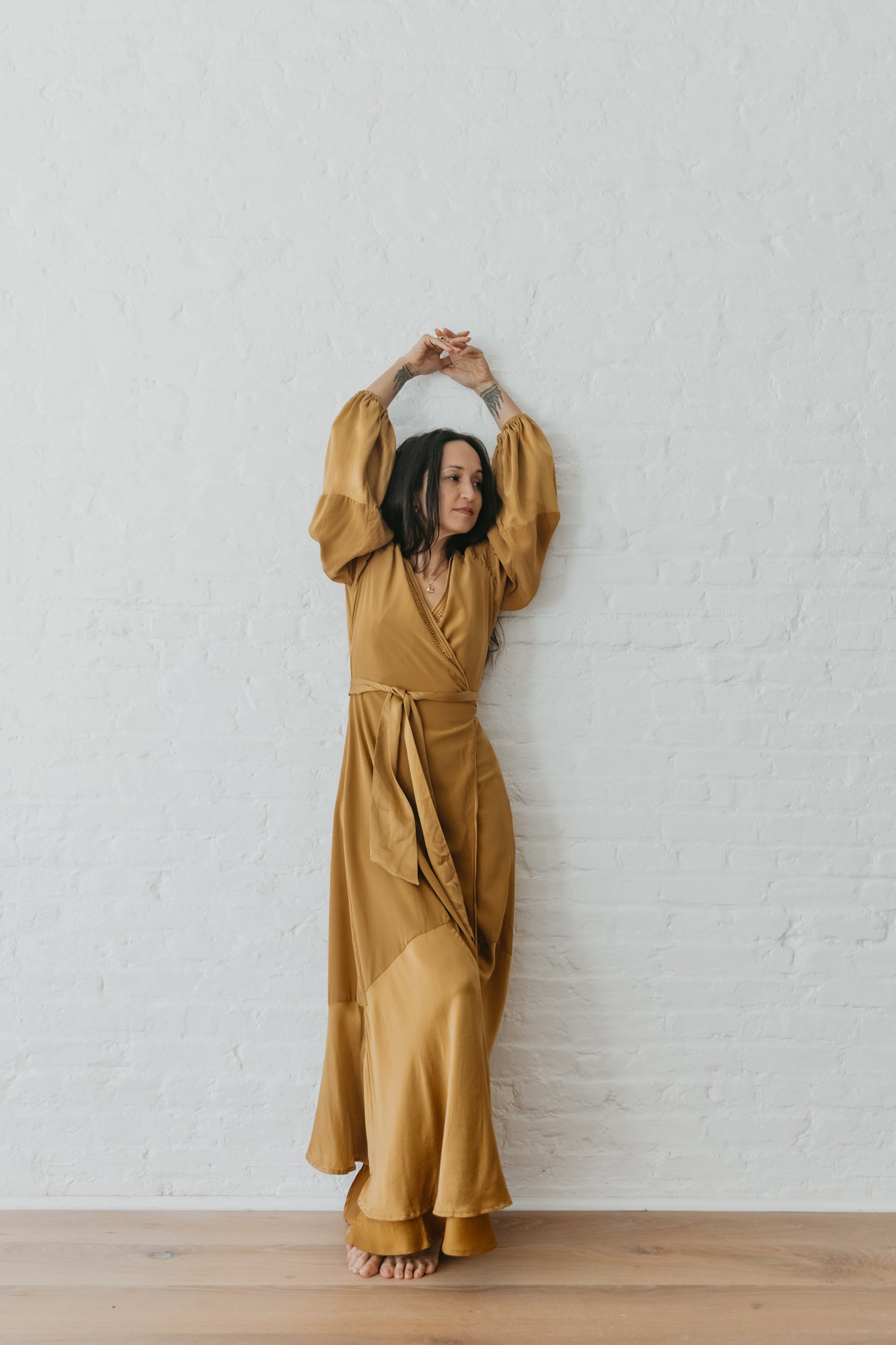 women wearing Goddess inspired silk wrap dress in warm brass tone
