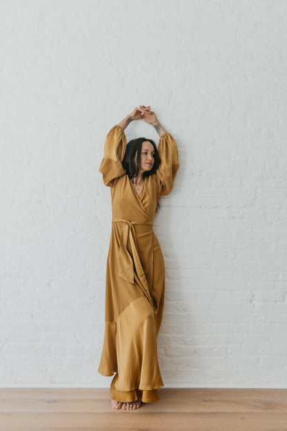 women wearing Goddess inspired silk wrap dress in warm brass tone
