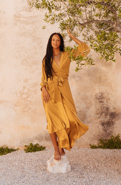 women wearing a Golden silk wrap dress with flowing balloon sleeves
