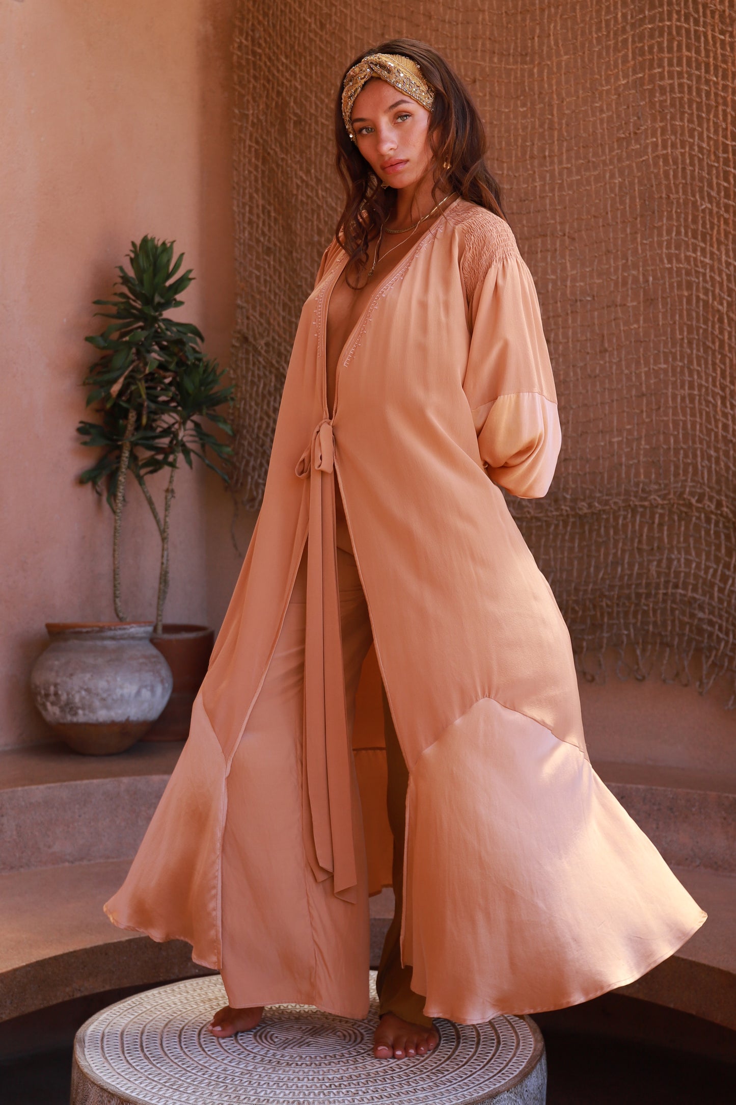 women wearing peach silk wrap dress with Bedouin inspired embroidery
