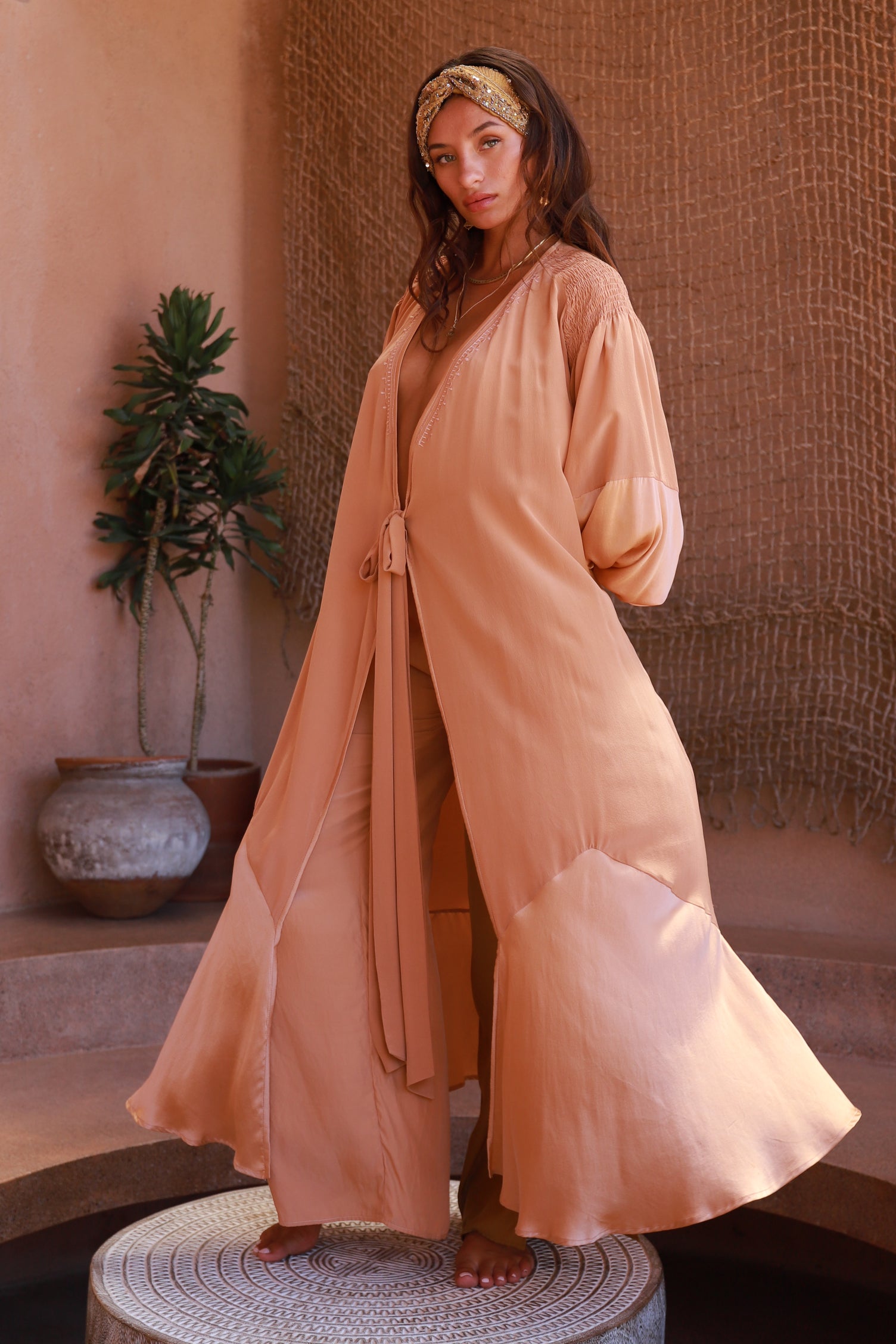 women wearing peach silk wrap dress with Bedouin inspired embroidery
