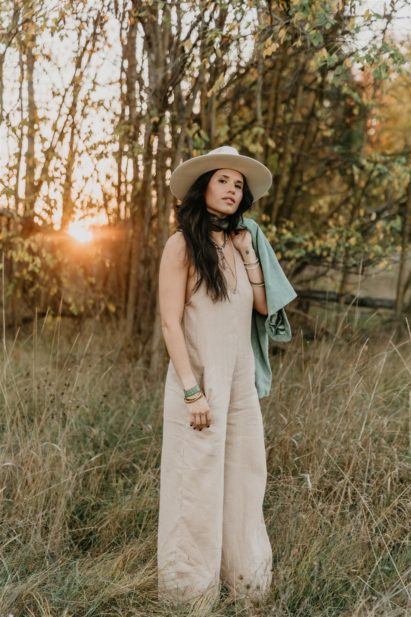 women wearing natural linen jumpsuit styled with hat in field