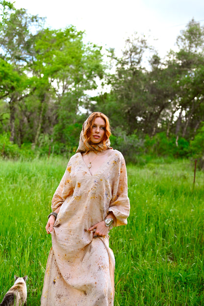 Deep V-neckline detail on The Flora Dress with botanical eco-print in golden amber and violet on natural cream linen by Payet Maison