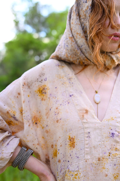 Close-up of botanical eco-printed linen showing golden amber and violet flower imprints on natural cream fabric, The Flora Dress by Payet Maison
