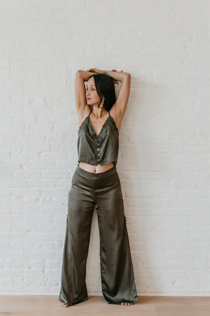 women wearing Flowing black silk pants in outdoor setting, Elegant wide leg silk trousers in deep black