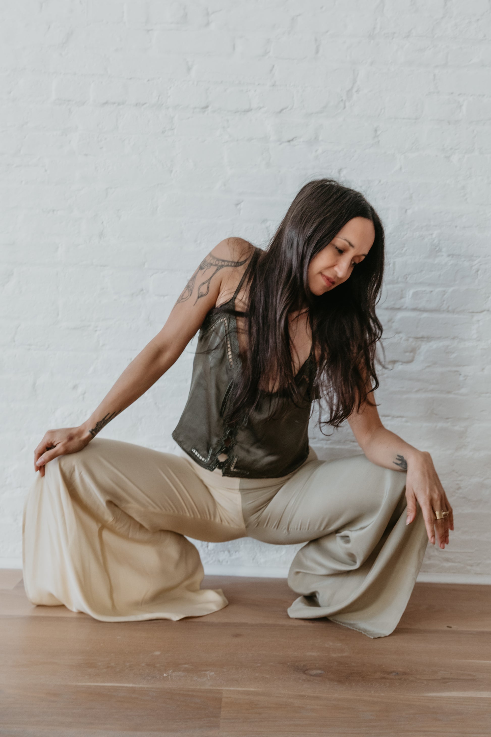 women wearing Elegant wide leg silk pants in soft green and champagne tones